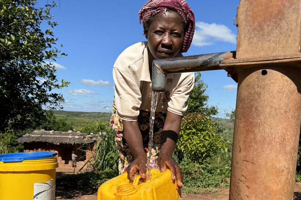 Isabel Luis fetching water at the water point in Bairro Nhaware