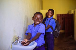 Two children smiling with safe water supply