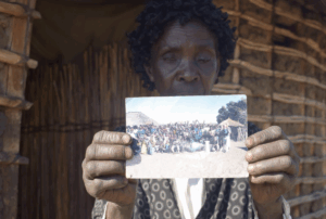 Woman holding up a village group picture