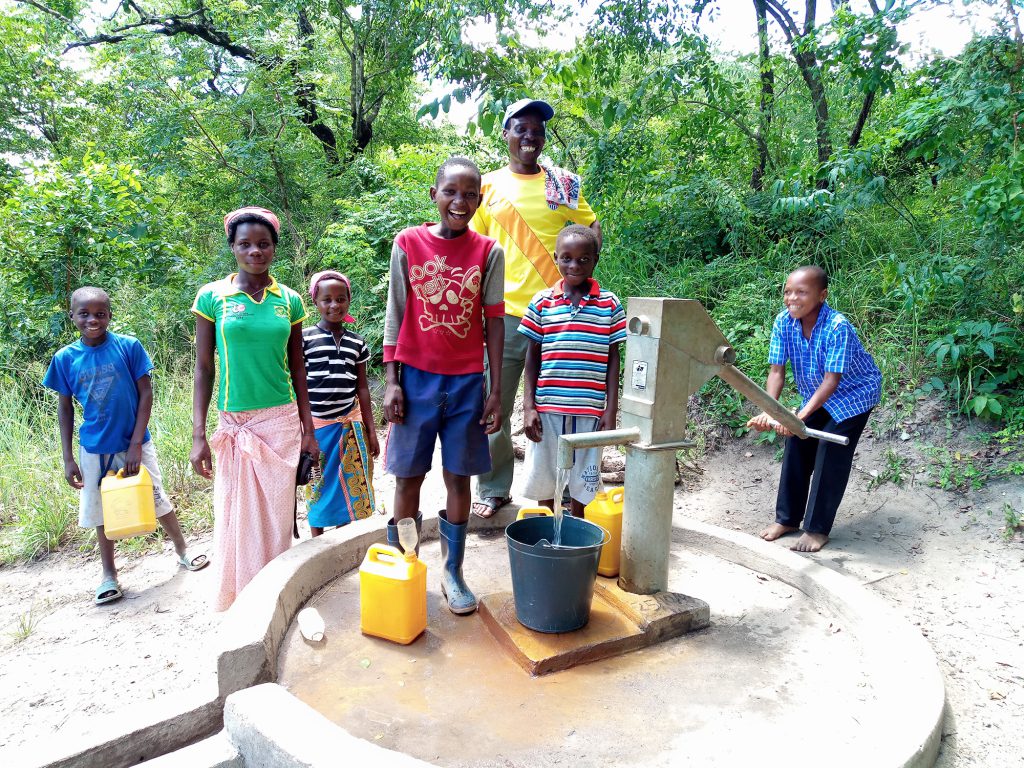 Students at Chimbua School with water pump and community members